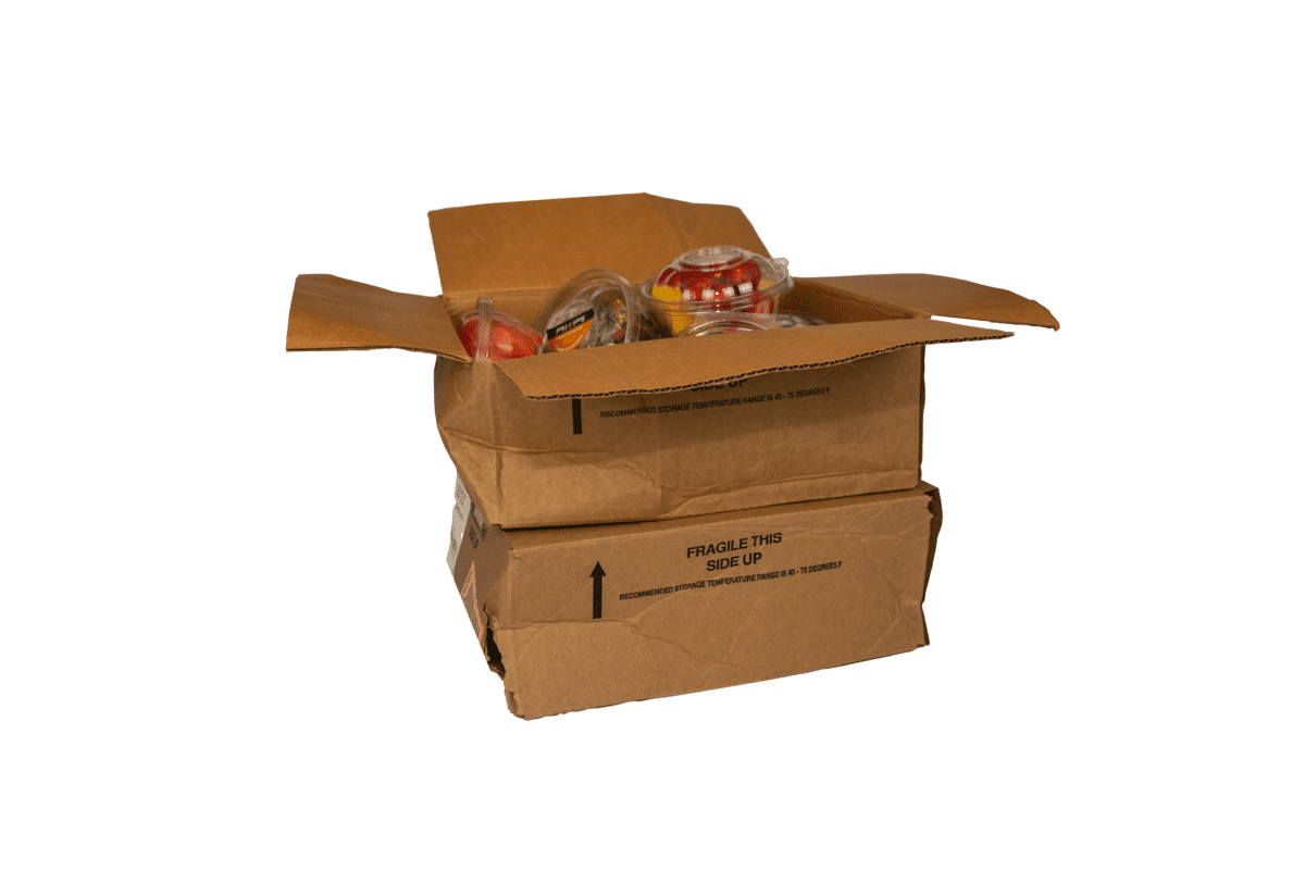A crushed corrugated cardboard box filled with produce shows signs of damage.
