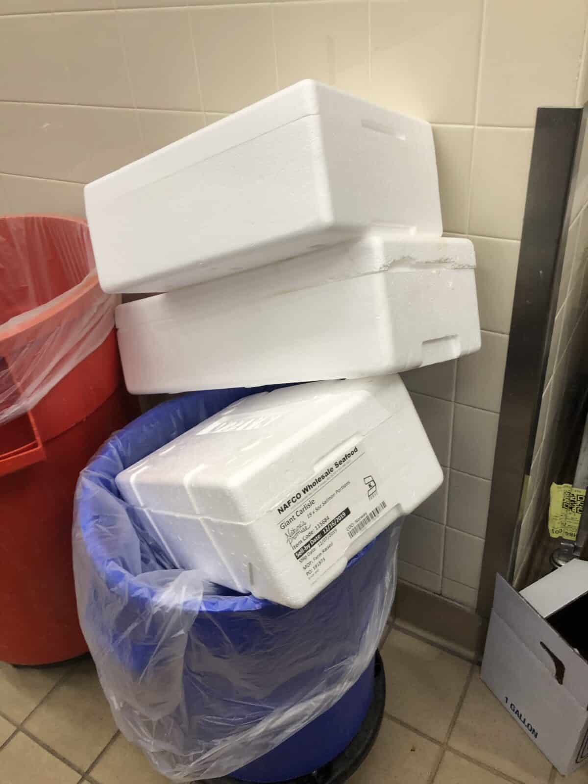 ESP insulated foam salmon storage containers are stacked in garbage cans.