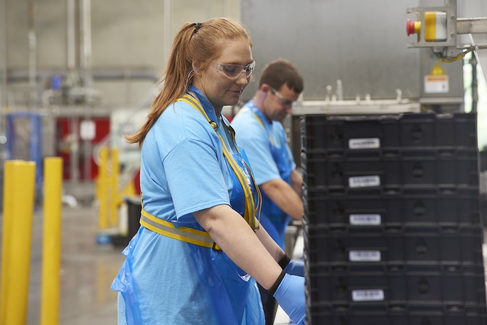 A Tosca service center worker stacks crates ready to be pooled