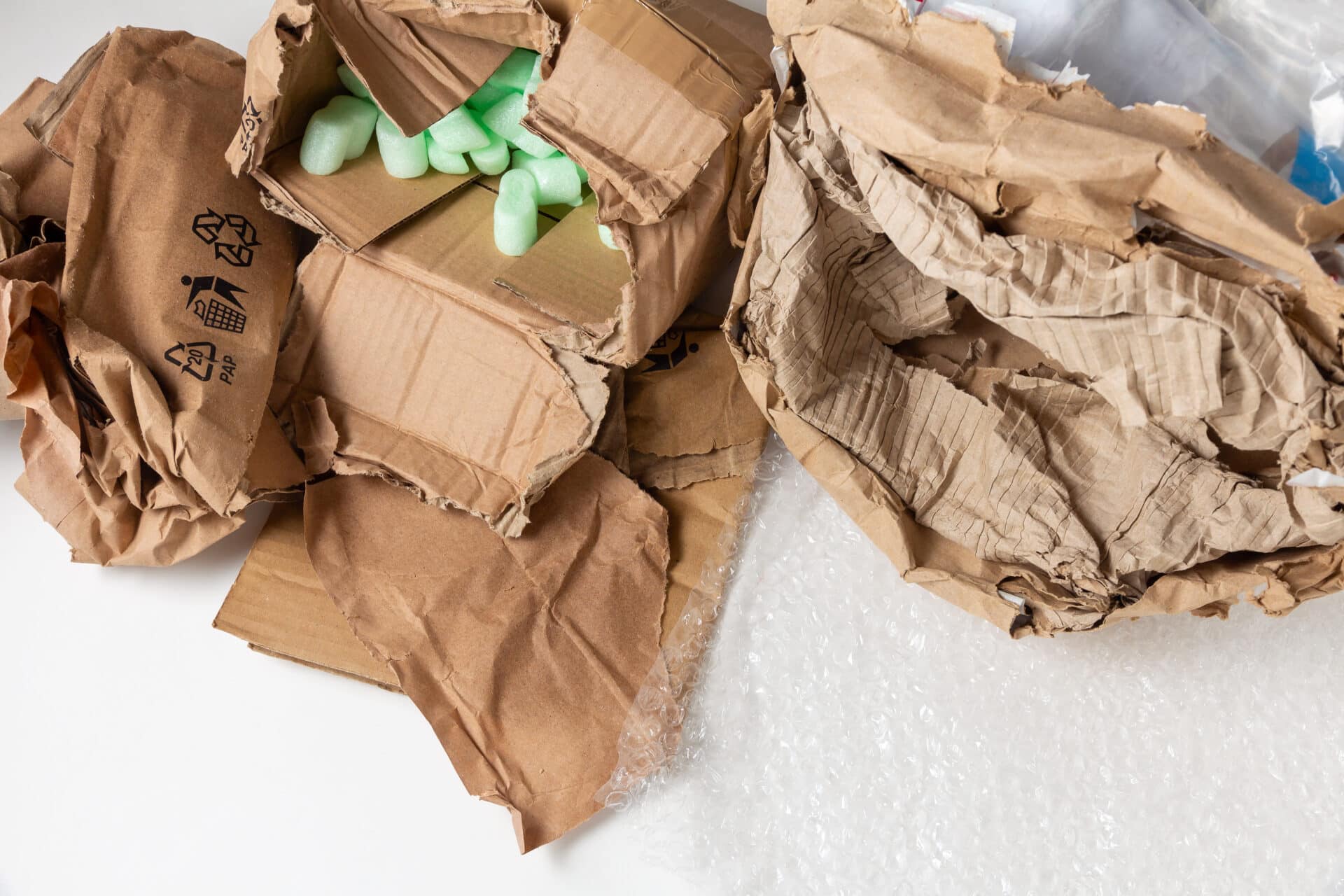 Wet damaged crumpled cardboard package with polyethylene and soft filling.